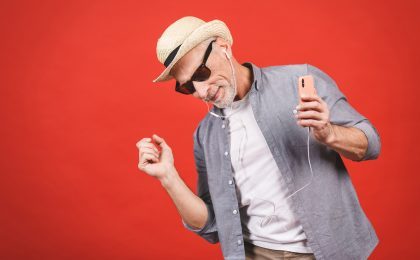 Portrait of senior happy cheerful elderly man dancing and listen